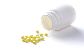 Pills with bottle on white background