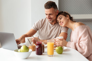 Obraz na płótnie Canvas Portrait of a happy loving couple having breakfast