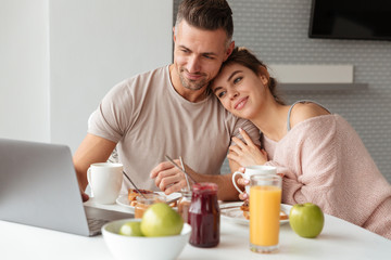 Obraz na płótnie Canvas Portrait of a smiling loving couple having breakfast