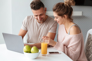 Obraz na płótnie Canvas Portrait of a happy couple shopping online with laptop