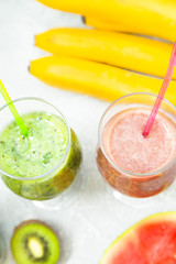 Tropical Healthy Smoothie with fresh kiwi, banana, watermelon and spinach on a light background, top view