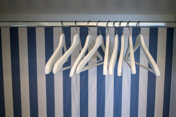 Kleiderbügel die an einer Kleiderstange in maritimen Ambiente hängen