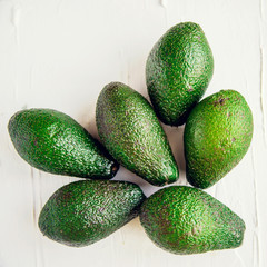 Avocado on the green and white background. Top view