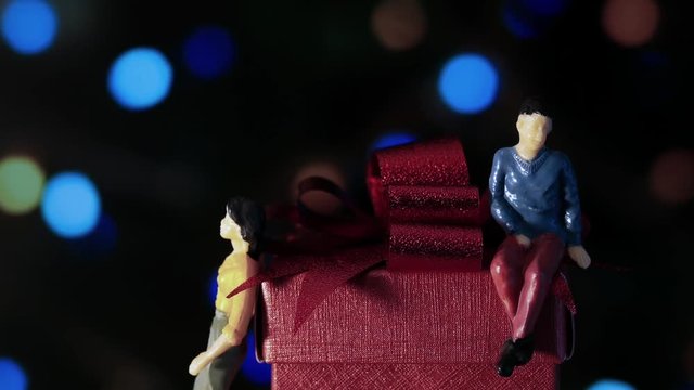 Miniature man and woman with red box in romantic night