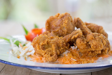 Fried chicken wing stick with coating flour in white dish and sweet chicken sauce on brown wooden table