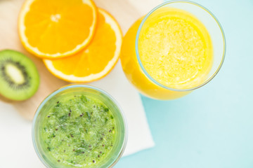 Tropical Smoothie Cocktail with fresh watermelon, orange, grapes and bananas. Light blue background, top viewHealthy food, Diet, Fitness, Dessert Concept