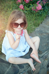 Baby girl smiling in sunglasses with raised finger