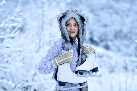 Woman happy smile with figure skates at trees in snow