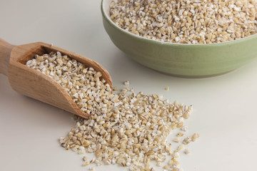 Pearl barley in the bowl isolated on the white background