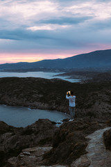 Fototapeta na wymiar Mesmerizing amazing scenery and landscape on hiking trail with urban adventurer explore nature wonders, overlooks epic views with sunset and photographs memories on smartphone