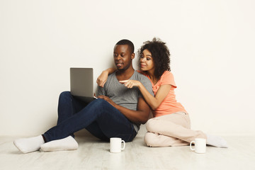 Fototapeta na wymiar Happy african-american couple shopping online on laptop