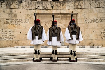 Greek Presidential Guard (evzone) in national clothes uniform at the tomb of unknown soldier in...