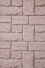 wall from a pink brick of a stone with a regular laying
