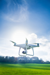 Picture of flying white drone camera in front of trees - 189495166