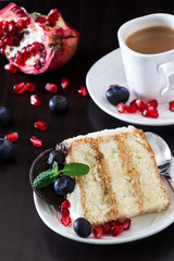Piece of layer cake with fresh blueberries, cream cheese and chocolate cookies. Dark wooden background. Romantic Valentine's Day concept.