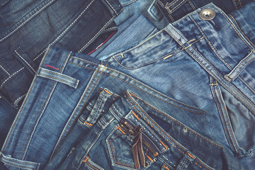 Jeans set of different colors stacked on a background, top view with a copy of the workspace, a concept of a trendy retro style