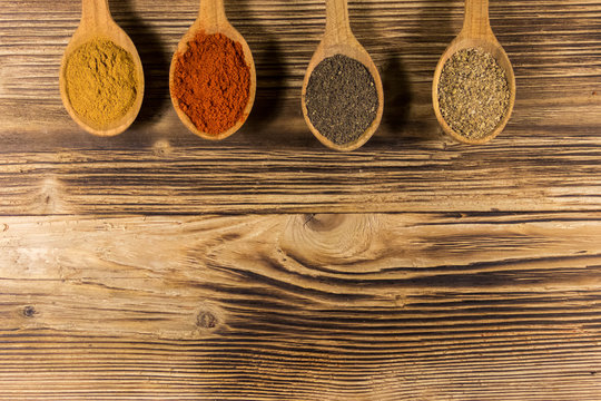 Assorted spices in wooden spoons on a table