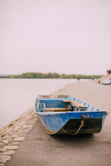 Синяя лодка на берегу реки