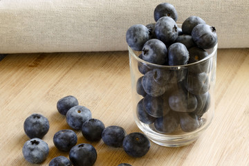 Blueberries in a glass on wooden background