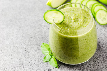 Detox cucumber green apple smoothie in a glass on concrete background. Selective focus, copy space.