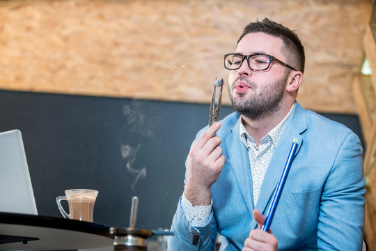 young casualy dressd guy smoking hookah at a coffee shop