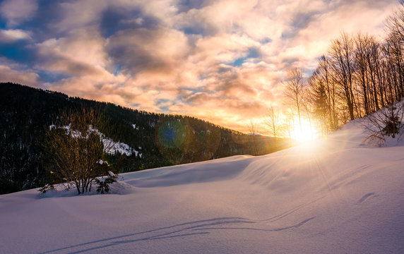 sun rising behind the snowy slope. wonderful nature winter scenery in mountainous area