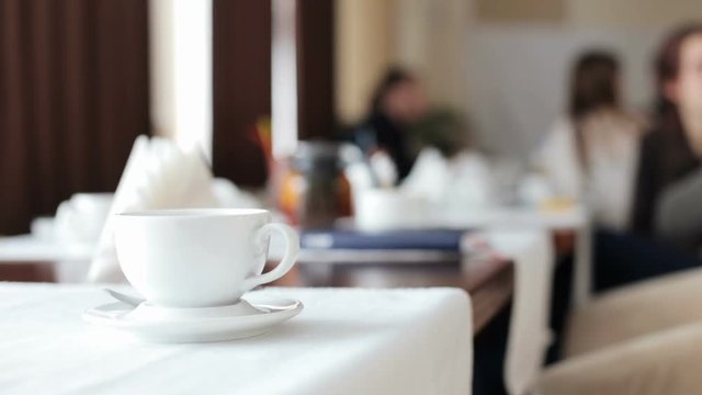 People at a meeting in a restaurant, against a background of a cup of tea
