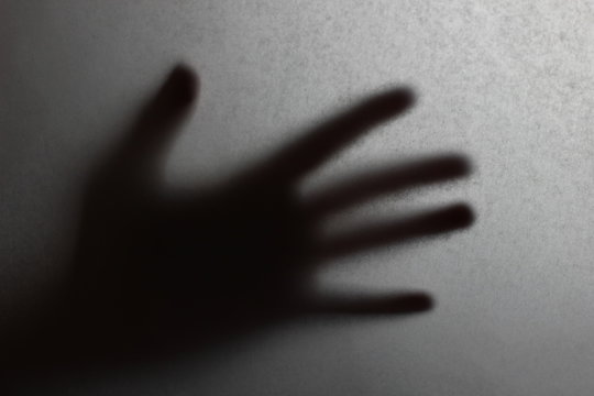 dark silhouette of a hand on blurred background