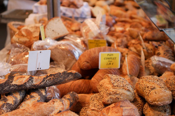 Bread shop in a street market. Baguette with poppy, muffins with white and black sesame loaves
