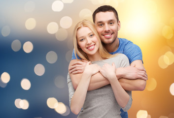 happy couple hugging over lights background