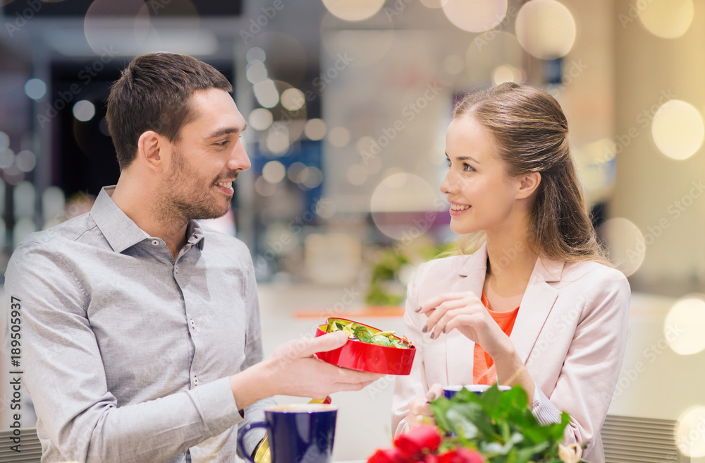 Poster happy couple with present and flowers in mall