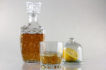 Glass of whisky with carafe and lemon