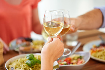 hands clinking wine glasses