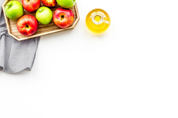 Apple cider vinegar in bottle among fresh apples on white background top view copy space