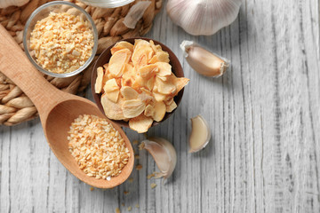 Composition with granulated dried garlic and flakes on wooden background © Africa Studio