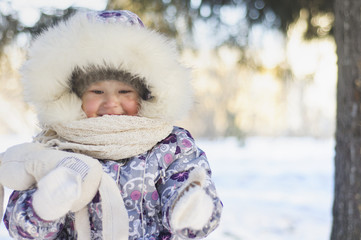 Little girl in winter Park in cold Sunny day