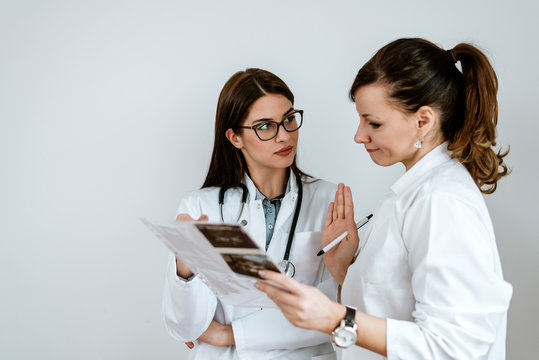 Two Female Doctors Consulting Each Other About Patients Diagnosis.