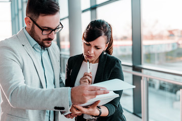 Businesswoman discussing documents with her male colleague at business meeting.