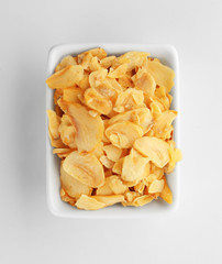 Dried garlic flakes in bowl on white background