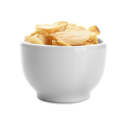 Dried garlic flakes in bowl on white background
