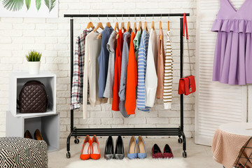 Rack with collection of clothes in dressing room