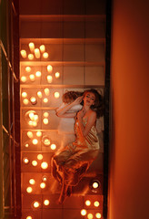 Beautiful young woman lying on stairs with burning candles