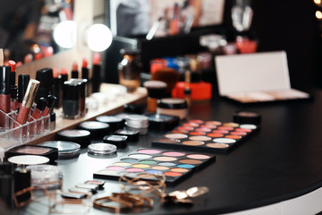 Decorative cosmetics and tools on dressing table in makeup room