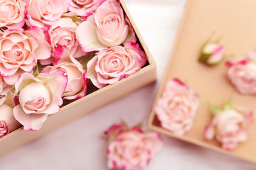 Box with beautiful roses on table, closeup