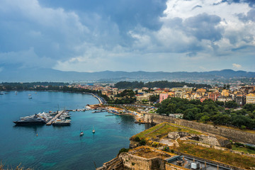 Aerial scenic view on old fortress in Corfu, historical part of city and parked boats and yachts on Ionian sea. Greece.