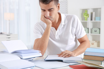 Fototapeta premium Male student preparing for exam at table indoors