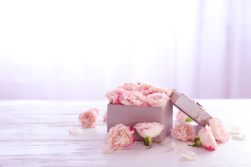 Gift box with flowers on wooden table