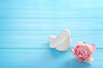Ceramic bird with flower on wooden table