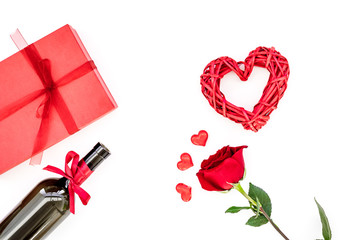 Present for Valentine day in red colors. Wine, rose, heart sign, gift box on white background top view