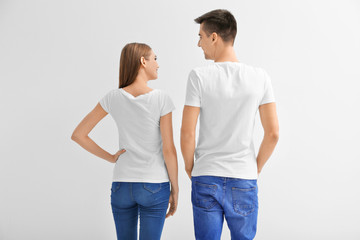 Young woman and man in t-shirts on white background. Mockup for design